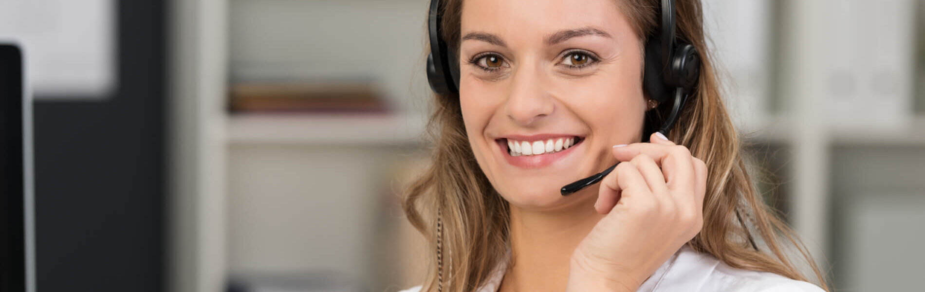 lächelnde mitarbeiterin telefoniert mit headset