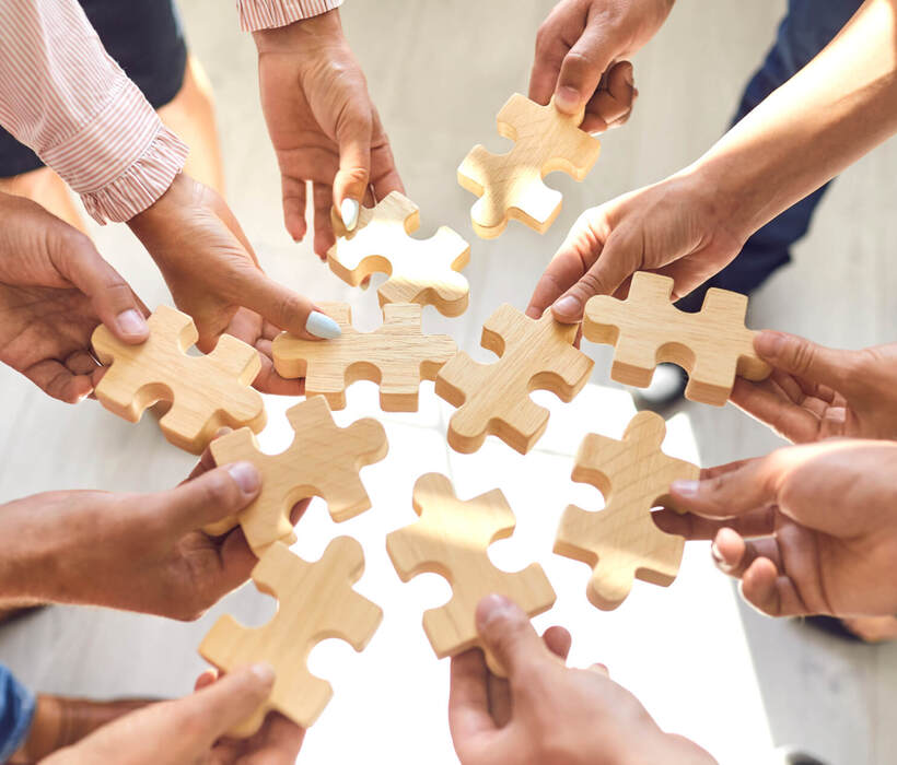 Mitarbeiter des Unternehmens fügen Puzzleteile zusammen